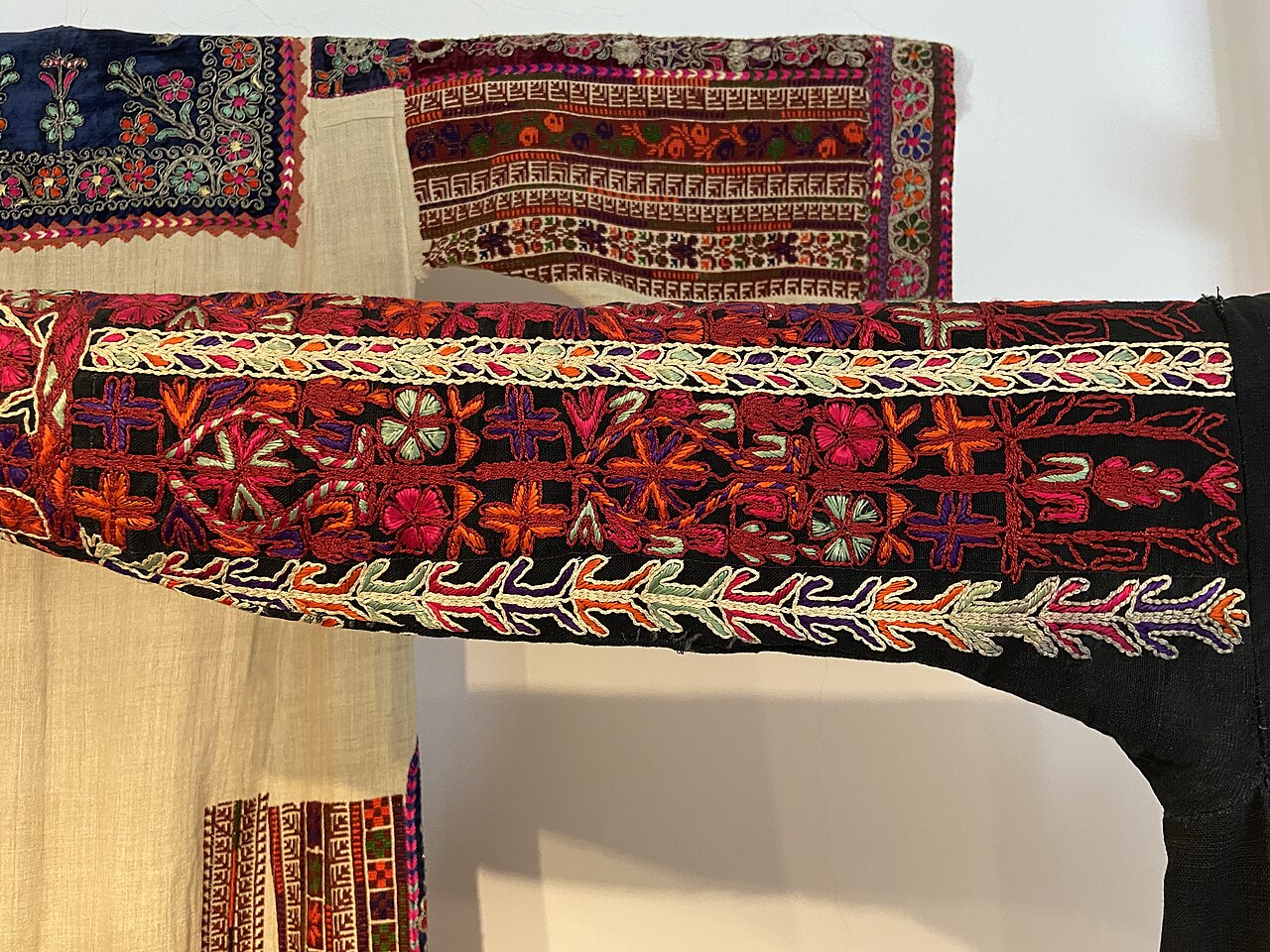 Red cross-stitch embroidery on the sleeves of a Palestinian dress
